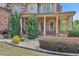 Inviting front yard landscaping with gravel, manicured shrubs, and covered porch with brick columns at 2932 Springbluff Ln, Buford, GA 30519