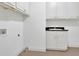 Bright laundry room with white cabinetry, granite counters, and tile flooring at 2932 Springbluff Ln, Buford, GA 30519