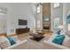 Spacious living room with stone fireplace, modern furniture, and abundant natural light at 2932 Springbluff Ln, Buford, GA 30519