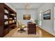 Office featuring hardwood floors, decorative rug, built-in bookcase, and window with shutters at 2932 Springbluff Ln, Buford, GA 30519