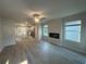 Open-concept living area with fireplace, ceiling fan, and seamless transition to the modern kitchen at 11045 Shadow Creek Ter, Hampton, GA 30228