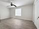 Clean bedroom featuring gray wood floors, a ceiling fan, and a bright window at 2880 Aspen Woods Entry, Doraville, GA 30360