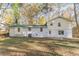 View of the two-story home with brick foundation and large backyard with green and brown trees at 4639 Hardwood Rd, Stone Mountain, GA 30083