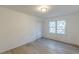 Well-lit bedroom featuring modern light fixture, wood-look flooring, and a large window at 4639 Hardwood Rd, Stone Mountain, GA 30083