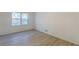 Cozy bedroom with light wood-look flooring, crisp white walls, and a window view at 4639 Hardwood Rd, Stone Mountain, GA 30083