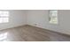 Bright bedroom featuring wood-look flooring, white walls, and natural light from two windows at 4639 Hardwood Rd, Stone Mountain, GA 30083