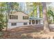 View of a yellow and white exterior elevation, complete with a two-car garage, set against a backdrop of lush woodland at 4639 Hardwood Rd, Stone Mountain, GA 30083
