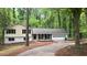 Exterior view of a single Gathering home, boasting a spacious driveway and a well-maintained lawn surrounded by mature trees at 4639 Hardwood Rd, Stone Mountain, GA 30083