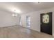 Inviting living area with wood flooring, enhanced by natural light streaming through large windows and a modern chandelier at 4639 Hardwood Rd, Stone Mountain, GA 30083