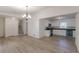 Open living space with modern floors, showcasing a seamless transition to the kitchen featuring white cabinetry and appliances at 4639 Hardwood Rd, Stone Mountain, GA 30083
