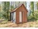 Exterior view of shed in backyard with small door and brown siding at 4639 Hardwood Rd, Stone Mountain, GA 30083