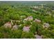 An aerial view shows several estates nestled in a neighborhood surrounded by a dense tree line at 8345 Jett Ferry Rd, Sandy Springs, GA 30350