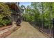 Backyard lawn with mature landscaping and fencing runs along the edge of this hillside property at 8345 Jett Ferry Rd, Sandy Springs, GA 30350