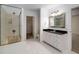 Bright bathroom featuring a glass enclosed shower, walk-in closet, white vanity, and neutral tile flooring at 8345 Jett Ferry Rd, Sandy Springs, GA 30350