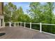 Spacious deck with black railing and lush greenery providing a serene outdoor experience at 8345 Jett Ferry Rd, Sandy Springs, GA 30350