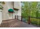 Wood deck features a awning covered door and iron railing that offers outdoor entertaining with wooded views at 8345 Jett Ferry Rd, Sandy Springs, GA 30350