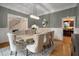 Chic dining room with contemporary lighting, neutral tones, and hardwood floors at 8345 Jett Ferry Rd, Sandy Springs, GA 30350