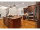 A kitchen with an island, double ovens, a wine cooler, and custom cabinets with granite countertops at 8345 Jett Ferry Rd, Sandy Springs, GA 30350