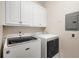 Laundry room with white washer and dryer and upper cabinets for storage at 8345 Jett Ferry Rd, Sandy Springs, GA 30350