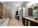 Luxurious main bathroom featuring a soaking tub, dual vanities, and a tiled shower at 8345 Jett Ferry Rd, Sandy Springs, GA 30350