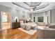 Spacious main bedroom with tray ceiling, hardwood floors, and adjoining bathroom at 8345 Jett Ferry Rd, Sandy Springs, GA 30350