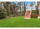 Spacious backyard with lush green grass, complemented by a wooden deck and surrounding trees at 2206 Loring Ct, Decatur, GA 30032