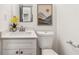 A well-lit half bathroom with a white vanity and a nature-inspired piece of artwork at 2206 Loring Ct, Decatur, GA 30032