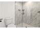 Modern tiled shower featuring glass door, shower head, and recessed shelf at 2206 Loring Ct, Decatur, GA 30032