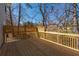 New wooden back deck with wooden railing overlooking a yard and treeline under a bright blue sky at 3362 Alexis Ct, Marietta, GA 30066