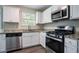 Bright kitchen showcasing stainless steel appliances, granite countertops, white cabinetry, and hardwood floors at 4096 Waldrop Hills Dr, Decatur, GA 30034