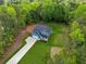 Aerial view displays the home with a well-kept lawn, attached garage, and surrounded by mature trees for privacy at 7031 Palomino Trl, Winston, GA 30187