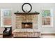 Close-up of stone fireplace with a wood mantel and hearth, flanked by bright windows at 7031 Palomino Trl, Winston, GA 30187