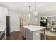 Open kitchen with island and modern pendant lighting, flowing seamlessly into the living area at 7031 Palomino Trl, Winston, GA 30187