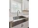 Close-up of stainless steel kitchen sink with white cabinets, modern faucet, and window view at 7031 Palomino Trl, Winston, GA 30187