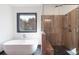 An elegant bathroom with a freestanding tub, a spacious glass shower and pebble floor at 750 Garden Reserve Ln, Alpharetta, GA 30005