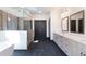 Modern bathroom featuring double vanities, a glass-enclosed shower, and sleek black tile floors at 750 Garden Reserve Ln, Alpharetta, GA 30005