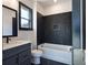 Bathroom with a black marble accent wall, a vanity with a blue cabinet, and a bathtub with shower at 750 Garden Reserve Ln, Alpharetta, GA 30005