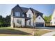 Charming two-story home featuring a mix of painted brick and vertical siding, an attached two-car garage, and well-manicured lawn at 750 Garden Reserve Ln, Alpharetta, GA 30005