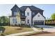 Charming two-story home featuring a mix of painted brick and vertical siding, an attached two-car garage, and well-manicured lawn at 750 Garden Reserve Ln, Alpharetta, GA 30005