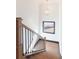 Staircase with natural wood treads and railing, and a modern light fixture and window at 750 Garden Reserve Ln, Alpharetta, GA 30005