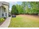 Expansive backyard with lush green grass, mature trees, and a patio area for outdoor entertaining at 4185 Cami Way, Buford, GA 30519