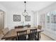 Bright dining room with chandelier, large wood table, and windows with shutter blinds at 4185 Cami Way, Buford, GA 30519