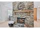 Stunning stone fireplace featuring a wooden mantel, decorative clock, and cozy ambiance in a well-lit space at 4185 Cami Way, Buford, GA 30519