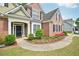 Beautiful entryway to a brick home with a well-maintained lawn, landscaped flower beds, and inviting walkway at 4185 Cami Way, Buford, GA 30519
