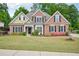 Charming brick home with manicured lawn, flowering shrubs, and a symmetrical design offering classic curb appeal at 4185 Cami Way, Buford, GA 30519