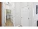 Hallway with wood floors, a laundry room featuring a washing machine, and white doors at 4185 Cami Way, Buford, GA 30519