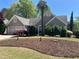 Charming home featuring manicured front lawn, mature landscaping, and an attached two-car garage at 2435 Jakin Way, Suwanee, GA 30024