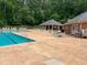 Community pool featuring lounge chairs, tables, and a covered structure alongside a brick building at 2435 Jakin Way, Suwanee, GA 30024