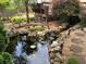 Backyard pond with a stone waterfall, lush plantings, and stepping stones at 2435 Jakin Way, Suwanee, GA 30024
