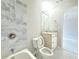 Bathroom features marble-tiled walls, updated lighting, vanity with marble top and open toilet seat at 3500 Millwater Xing, Dacula, GA 30019